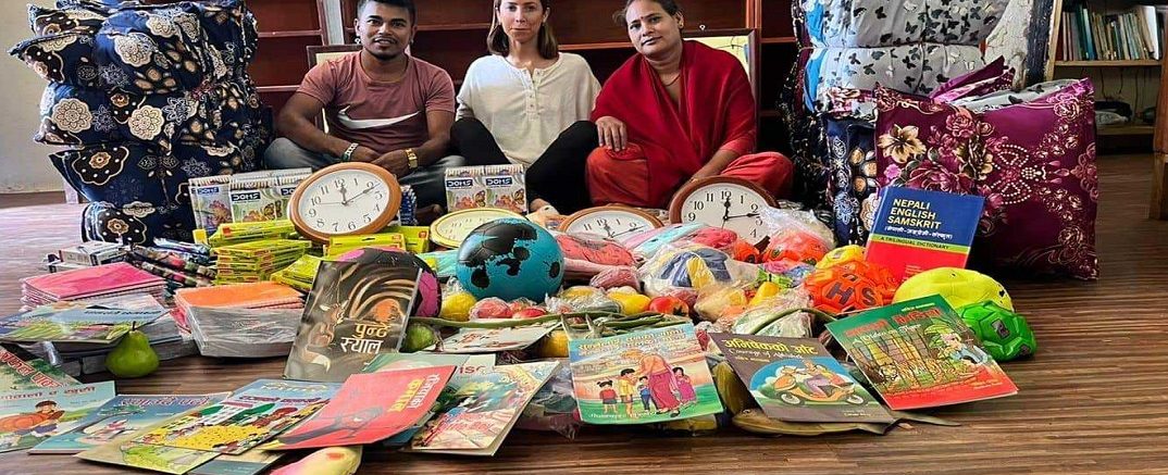 Volunteer donating study and sports material to rural school